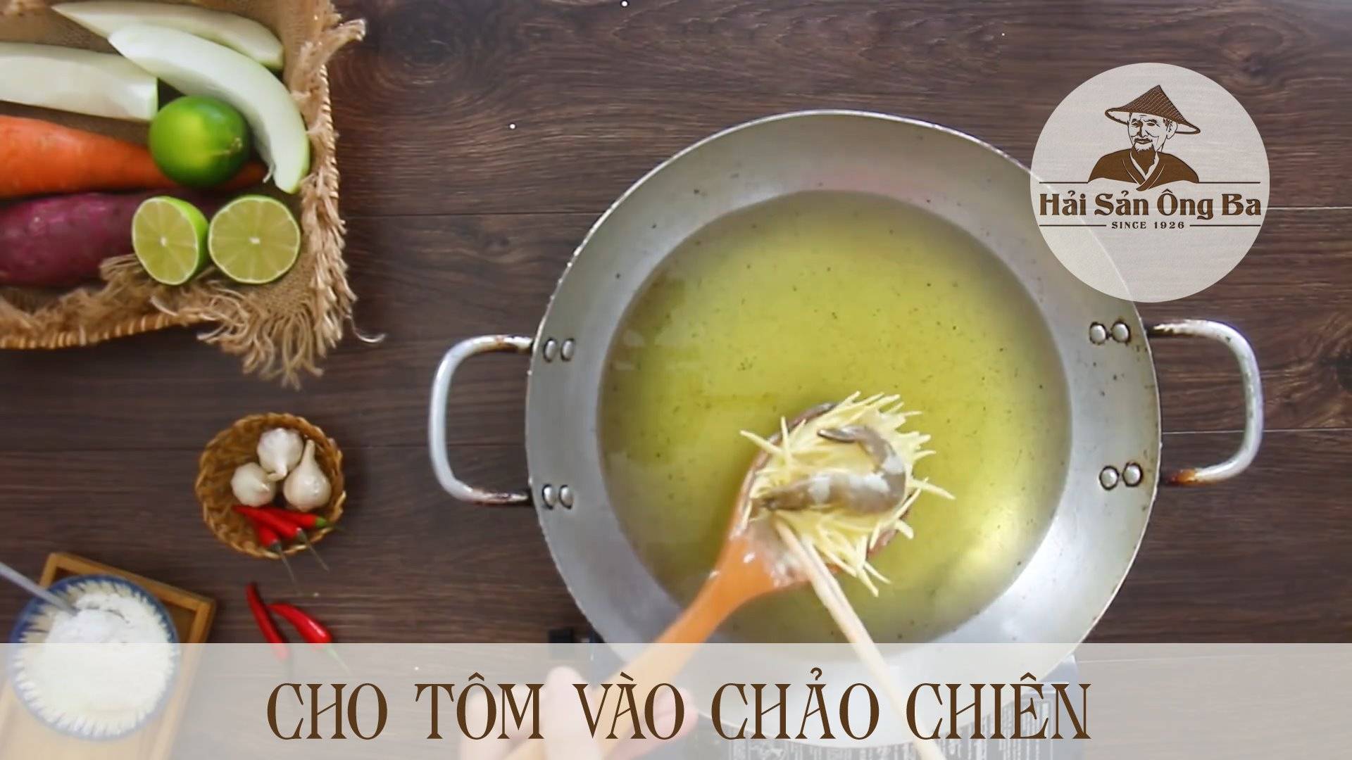 chiên tôm trong chảo dầu, cái chảo, lát chanh, quả ớt, củ tỏi trên bàn nóng,