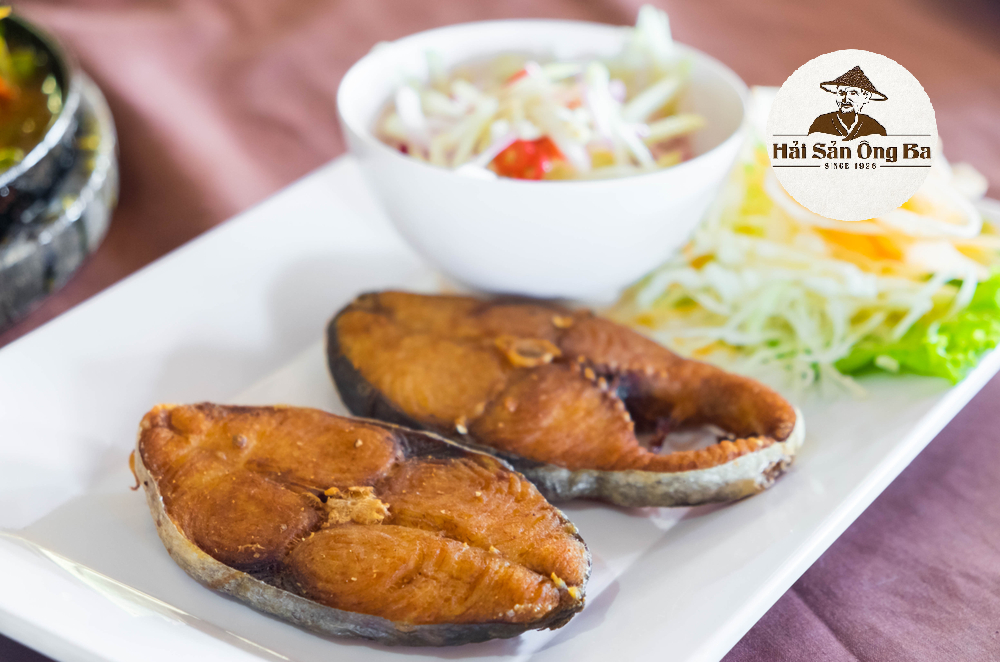 dĩa cá thu héo ( một nắng ) kho, bát rau ở trên bàn